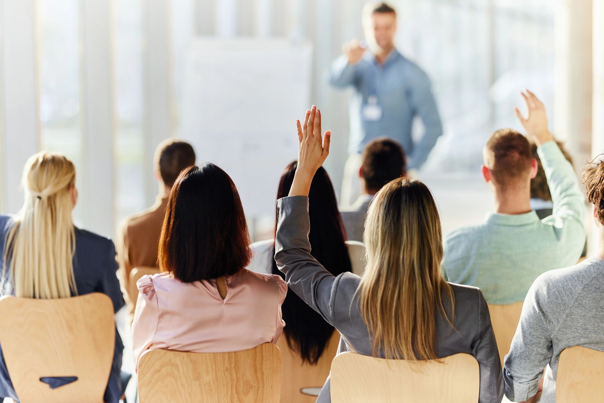 Corporate training session with participant raising a hand